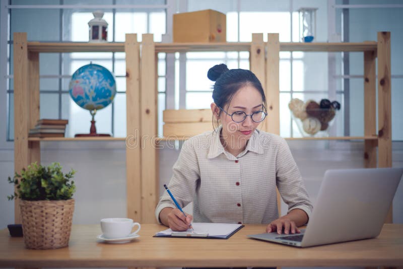 O proprietário empresarial asiático da mulher trabalha em casa fotografia de stock O proprietário empresarial asiático da mulher trabalha em casa fotografia de stock