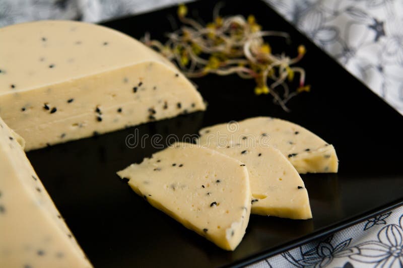 Queijo caseiro com sementes de Nigella sativa e brotos de rabanete fotos de stock royalty free