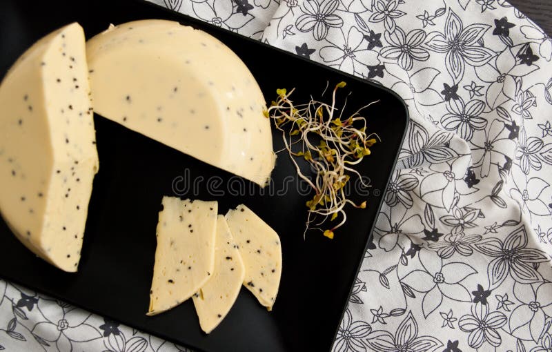 Queijo caseiro com sementes de Nigella sativa e brotos de rabanete imagens de stock