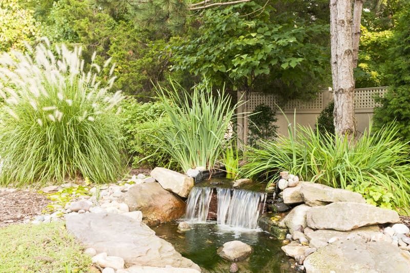 A quiet, decorative, landscaped waterfall in the backyard of a private home. A quiet, decorative, landscaped waterfall in the backyard of a private home.