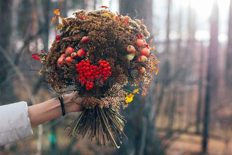 O ramalhete secado floresta do inverno do outono nas mãos da mulher