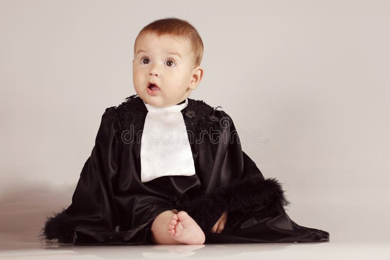 O rapaz pequeno bonito vestiu-se na veste que tem o divertimento e que sorri no fundo isolado imagens de stock royalty free O rapaz pequeno bonito vestiu-se na veste que tem o divertimento e que sorri no fundo isolado imagens de stock royalty free