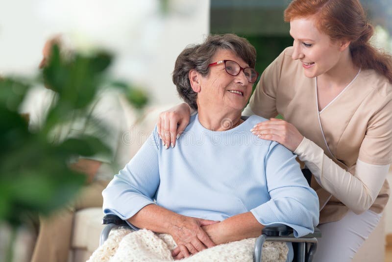 O relacionamento entre a enfermeira de sorriso e feliz amigáveis desabilitaram g foto de stock O relacionamento entre a enfermeira de sorriso e feliz amigáveis desabilitaram g foto de stock