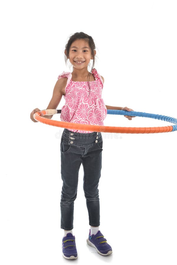 O retrato da menina asiática pequena feliz da criança que joga o hulahoop está ligada foto de stock O retrato da menina asiática pequena feliz da criança que joga o hulahoop está ligada foto de stock