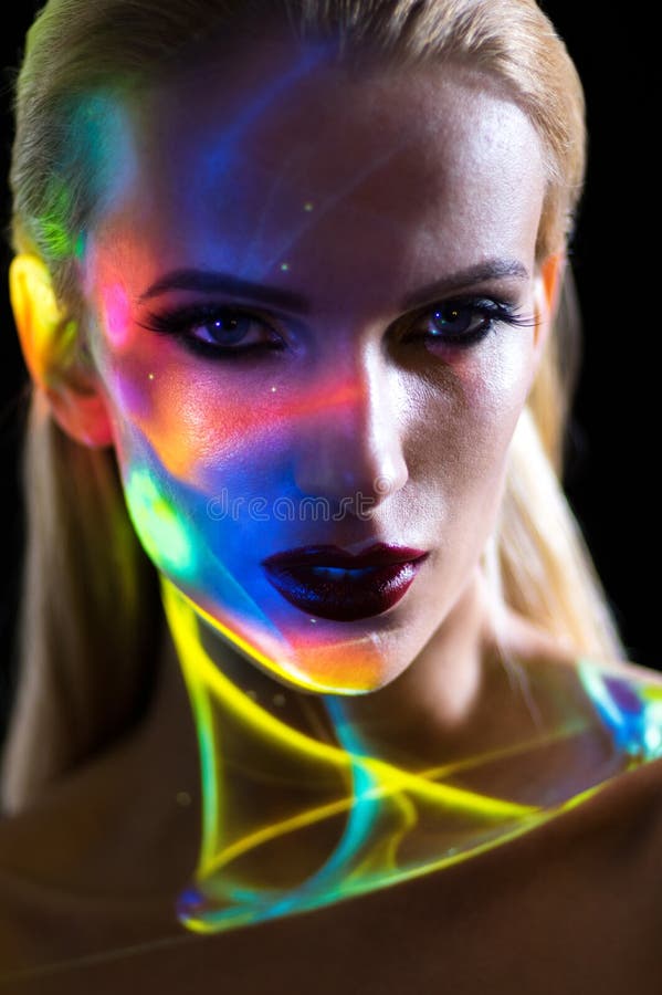 O retrato da mulher loura com brilho ilumina-se na cara foto de stock royalty free O retrato da mulher loura com brilho ilumina-se na cara foto de stock royalty free