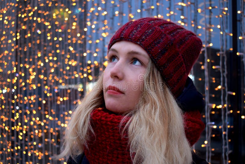 O retrato de um vermelho vestindo da mulher loura nova fez malha o chapéu e o lenço imagens de stock O retrato de um vermelho vestindo da mulher loura nova fez malha o chapéu e o lenço imagens de stock