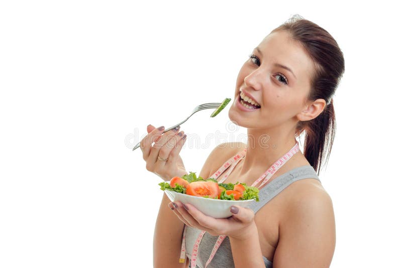 Portrait of a beautiful young girl who holds in her hand a plate with salad looks into the camera and smiling on white background. Portrait of a beautiful young girl who holds in her hand a plate with salad looks into the camera and smiling on white background