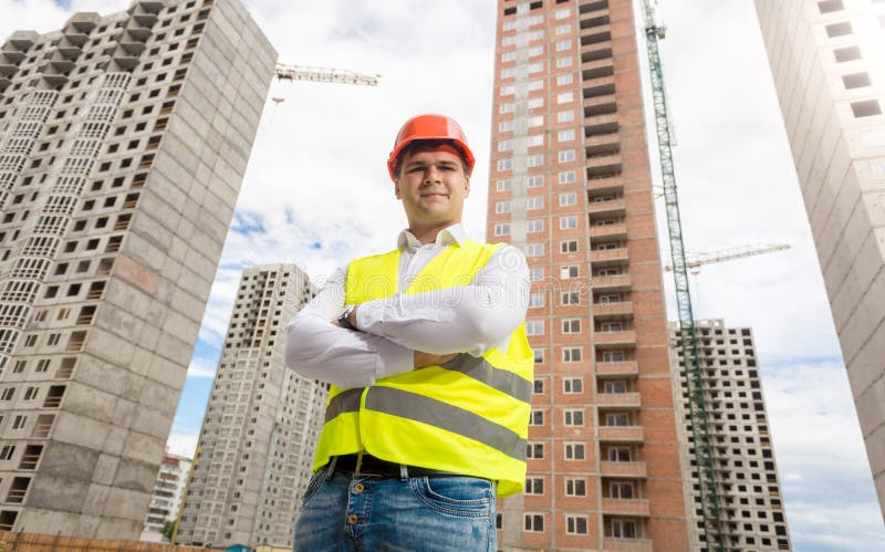 O retrato do arquiteto no capacete de segurança e a segurança investem o levantamento contra imagens de stock O retrato do arquiteto no capacete de segurança e a segurança investem o levantamento contra imagens de stock