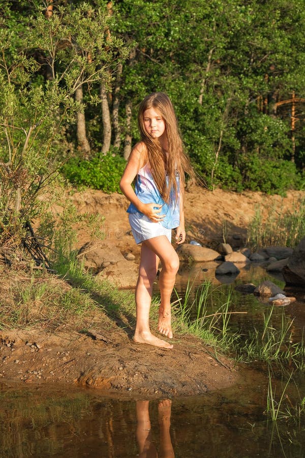 O retrato ensolarado brilhante bonito de uma menina no mar fotos de stock O retrato ensolarado brilhante bonito de uma menina no mar fotos de stock
