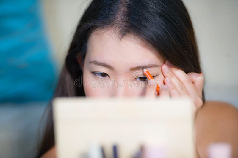 O retrato natural do estilo de vida da mulher coreana asiática bonita e feliz nova em casa que aplica-se compõe o perfilamento da imagem de stock O retrato natural do estilo de vida da mulher coreana asiática bonita e feliz nova em casa que aplica-se compõe o perfilamento da imagem de stock