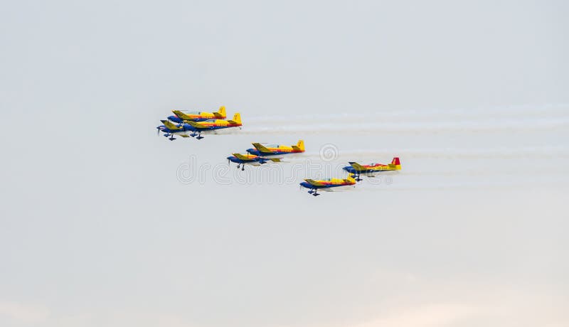 O Romanian Hawks os pilotos da equipe com seus aviões coloridos que treinam no céu azul imagem de stock O Romanian Hawks os pilotos da equipe com seus aviões coloridos que treinam no céu azul imagem de stock