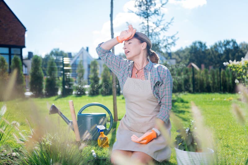 O sentimento bonito da mulher da família esgotado após a plantação floresce o dia inteiro imagem de stock O sentimento bonito da mulher da família esgotado após a plantação floresce o dia inteiro imagem de stock