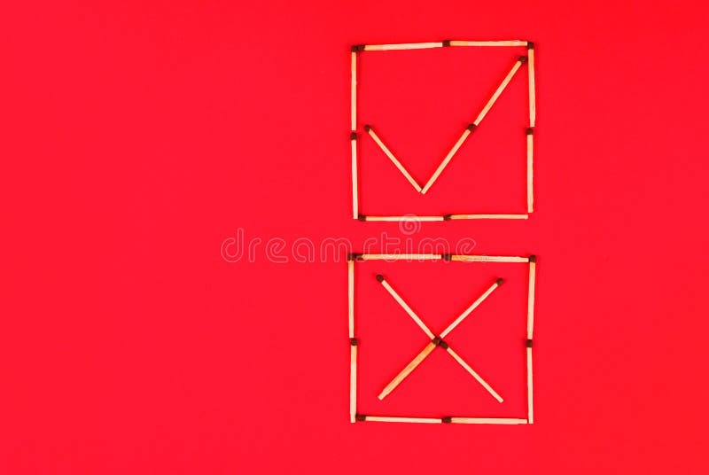 O sinal correto e incorretamente nas caixas de seleção faz dos fósforos no fundo vermelho fotografia de stock O sinal correto e incorretamente nas caixas de seleção faz dos fósforos no fundo vermelho fotografia de stock