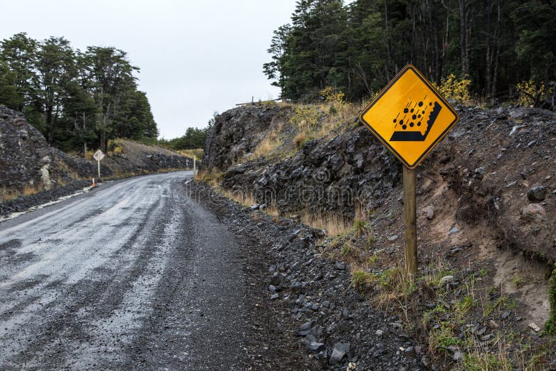 O sinal de aviso para cair balança em uma estrada unpaved Torres del Paine, o Chile foto de stock O sinal de aviso para cair balança em uma estrada unpaved Torres del Paine, o Chile foto de stock