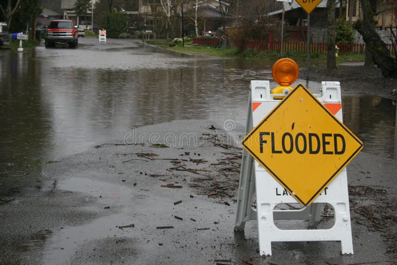 O sinal inundado senta-se em uma rua inundada