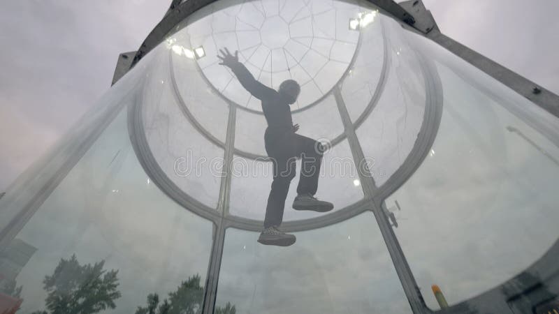 O skydiver do homem voa no túnel de vento Túnel de vento saltando em queda livre interno foto de stock O skydiver do homem voa no túnel de vento Túnel de vento saltando em queda livre interno foto de stock