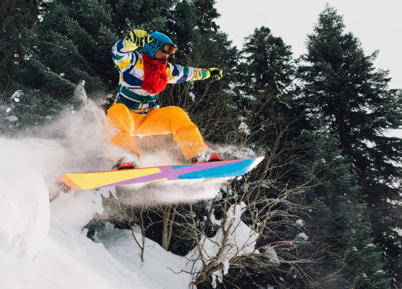 O Snowboarder está saltando muito altamente e está freeriding do monte na floresta da montanha fotos de stock O Snowboarder está saltando muito altamente e está freeriding do monte na floresta da montanha fotos de stock