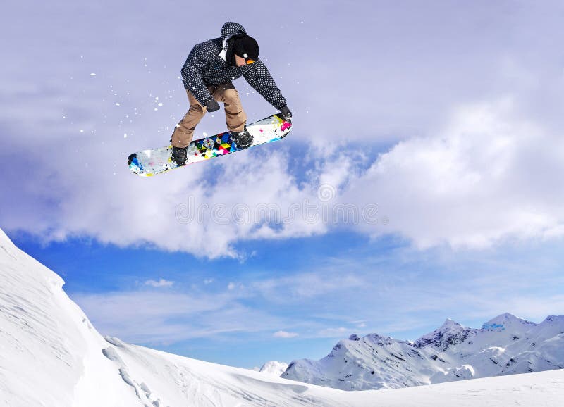 O Snowboarder que salta através do ar com o céu no fundo foto de stock O Snowboarder que salta através do ar com o céu no fundo foto de stock