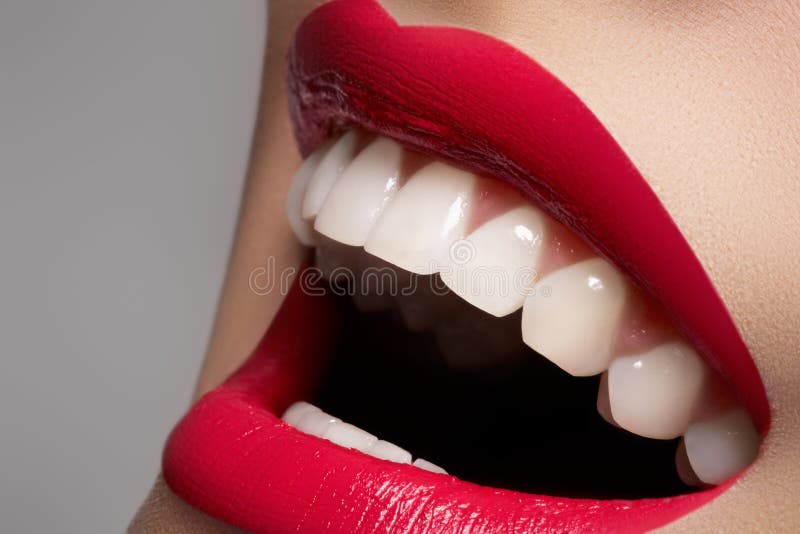 O sorriso fêmea feliz com dentes brancos &amp; os bordos preparam