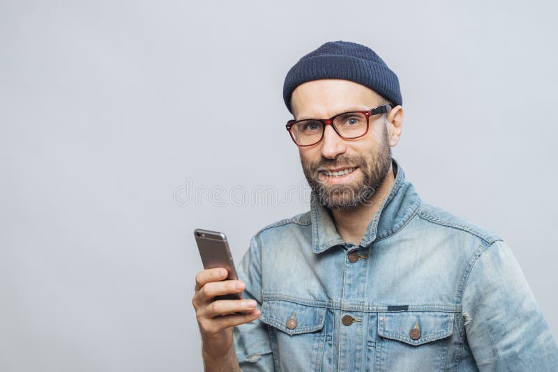O tiro de Stusio do homem farpado feliz com restolho guarda esperto moderno imagem de stock royalty free O tiro de Stusio do homem farpado feliz com restolho guarda esperto moderno imagem de stock royalty free