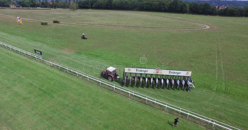 O trator aéreo do zangão 4k da trilha de corrida de cavalos puxa começar a barreira