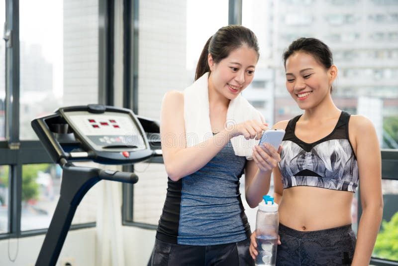 O treinador do Gym está mostrando o resultado do treinamento fotografia de stock O treinador do Gym está mostrando o resultado do treinamento fotografia de stock