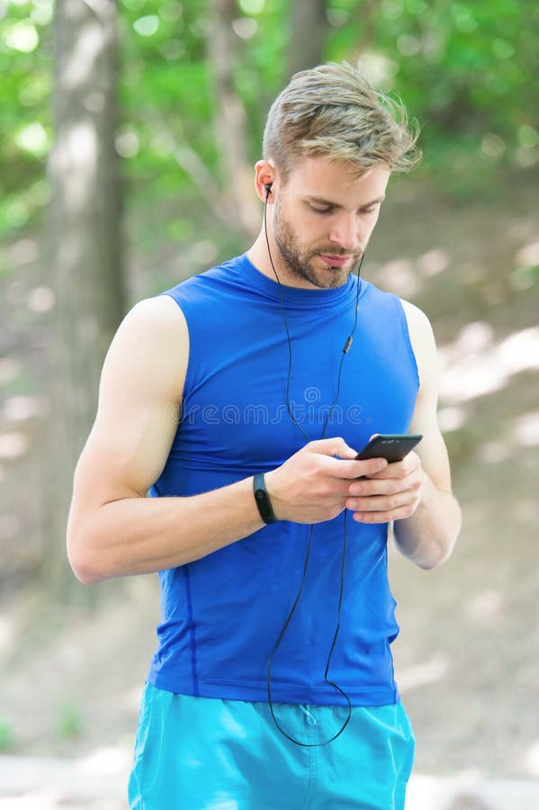O treinamento com aplicação do esporte é mais divertimento Aplica??o estabelecida Desportista com smartphone e o relógio esperto imagens de stock royalty free O treinamento com aplicação do esporte é mais divertimento Aplica??o estabelecida Desportista com smartphone e o relógio esperto imagens de stock royalty free