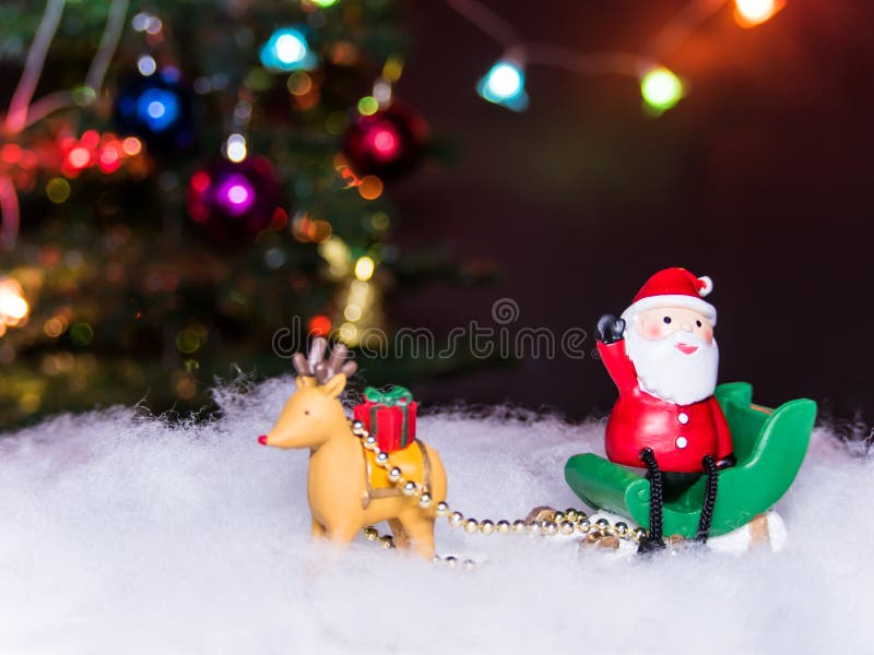 O trenó Papai Noel do verde do talão da rena senta-se gesticula sobre sua mão foto de stock O trenó Papai Noel do verde do talão da rena senta-se gesticula sobre sua mão foto de stock
