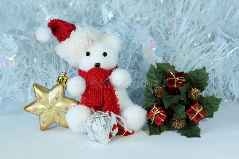 O urso polar que veste um chapéu e um lenço vermelho levantou ao lado dos presentes connosco brilhantes em uma decoração do feria fotos de stock O urso polar que veste um chapéu e um lenço vermelho levantou ao lado dos presentes connosco brilhantes em uma decoração do feria fotos de stock