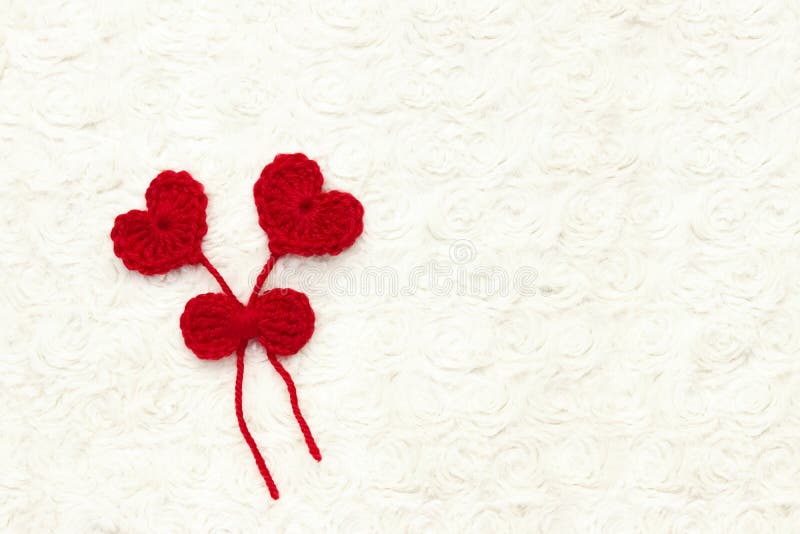 O vermelho dois faz crochê corações de lãs e a fita no branco faz crochê o fundo O conceito para o 14 de fevereiro, dia de são va fotografia de stock royalty free O vermelho dois faz crochê corações de lãs e a fita no branco faz crochê o fundo O conceito para o 14 de fevereiro, dia de são va fotografia de stock royalty free
