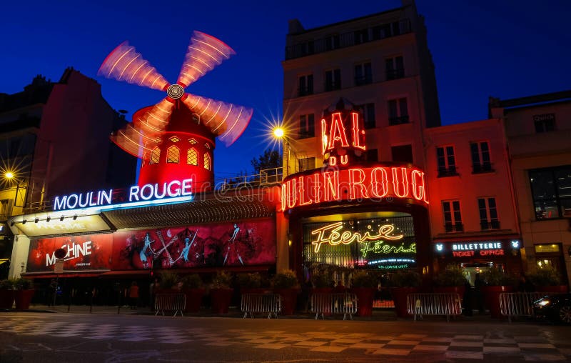 O vermelho famoso de Moulin da taberna na noite, área de Montmartre, Paris, França imagem de stock O vermelho famoso de Moulin da taberna na noite, área de Montmartre, Paris, França imagem de stock