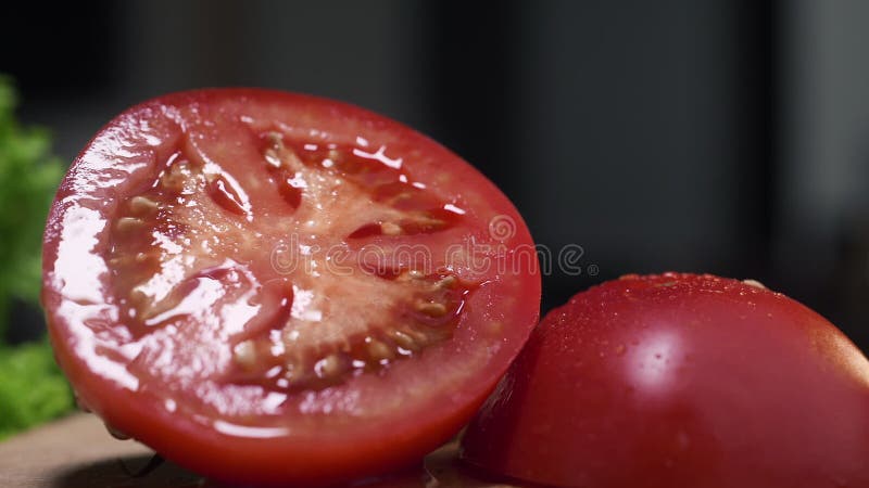 O vídeo macro do tomate suculento vermelho cutted ao meio, vegetais crus na cozinha, fecha-se acima do alimento, tomates isolados