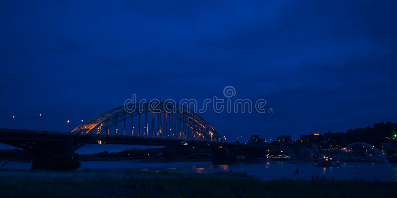 O Waalbridge Nijmegen durante a noite fotografia de stock O Waalbridge Nijmegen durante a noite fotografia de stock