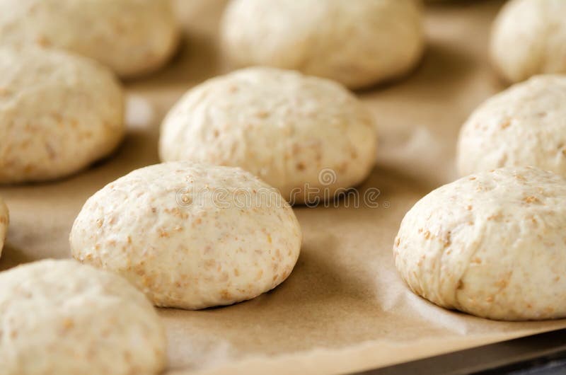 Oat bread buns on baking sheet