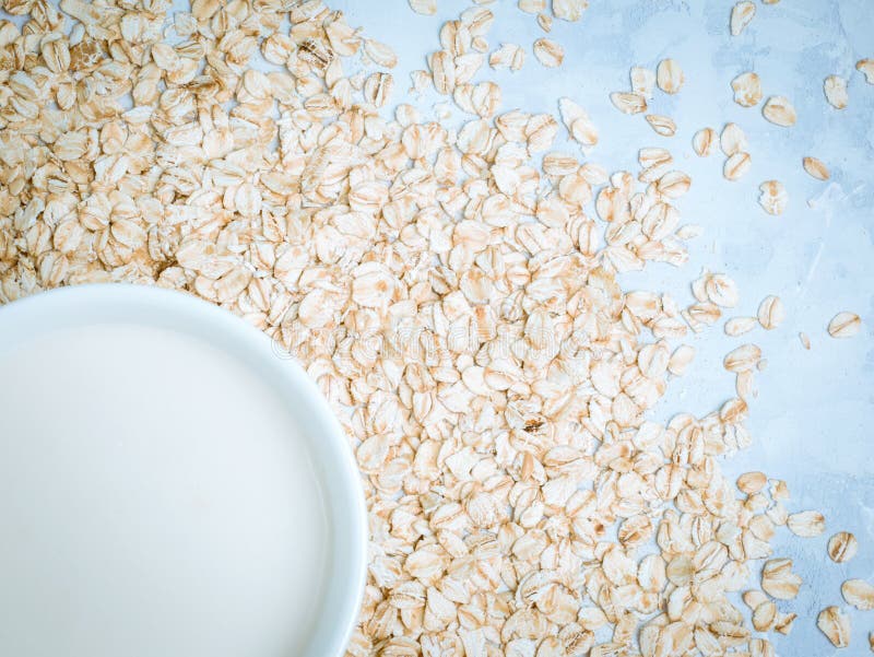 Oat Milk Drink in White Cup and Cereal Flakes on Kitchen Bench. Flat
