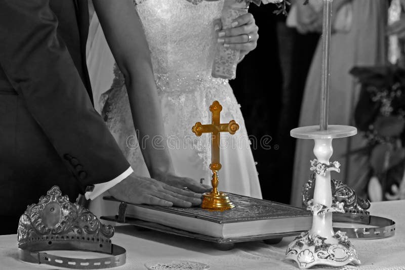 Groom and bride swear with hand on bible faith in marriage, in a church. Groom and bride swear with hand on bible faith in marriage, in a church