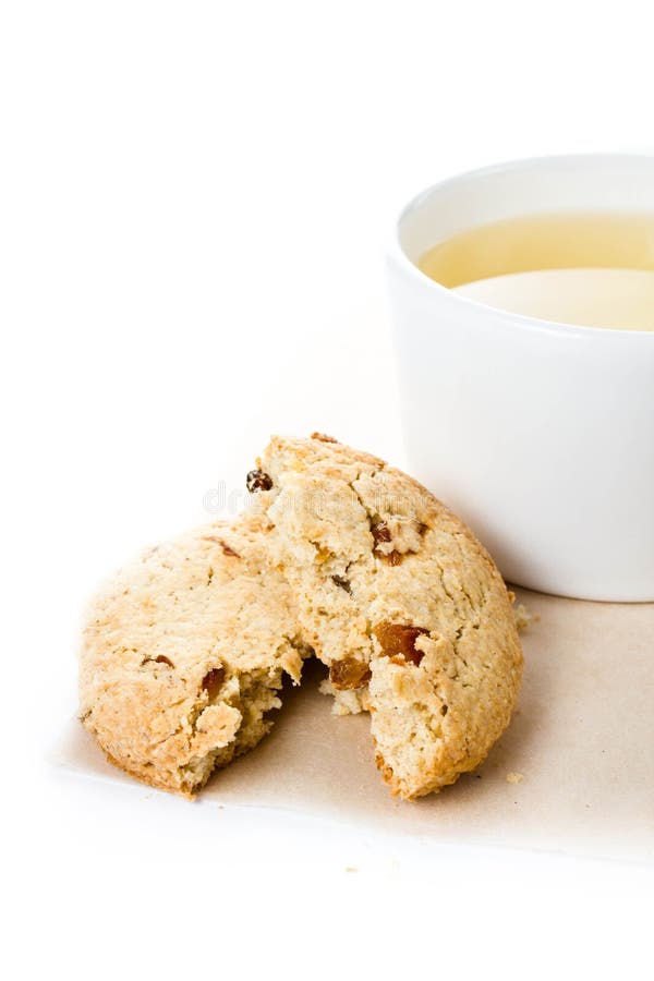 Oatmeal crumbled cookie with raisins and cup of green tea on w