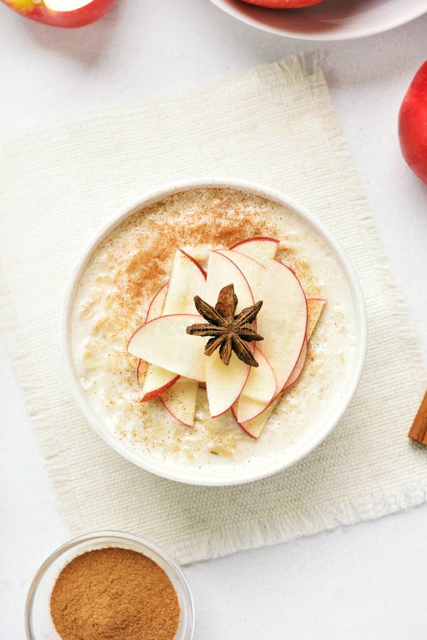 Oatmeal porridge with red apple slices and cinnamon