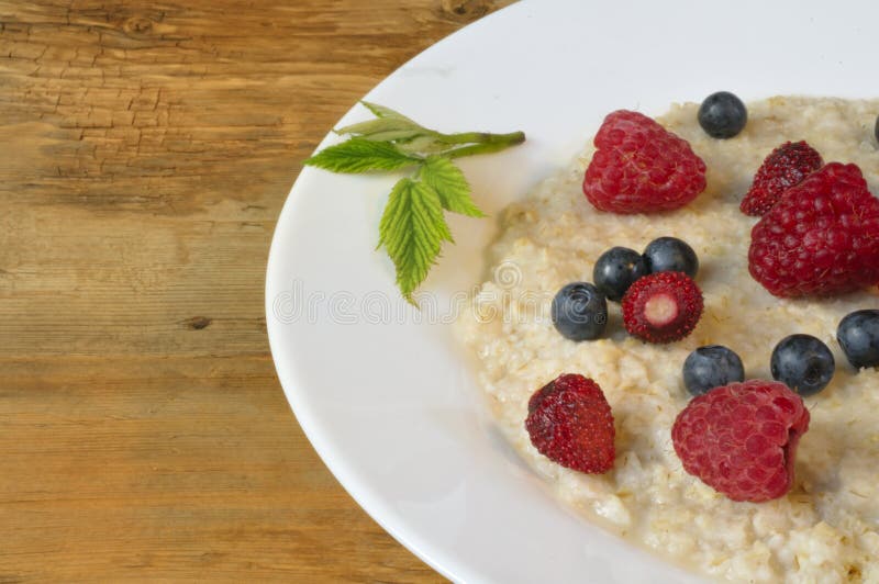 Oatmeal w talerzu na drewnianym tle zdjęcie royalty free Oatmeal w talerzu na drewnianym tle zdjęcie royalty free