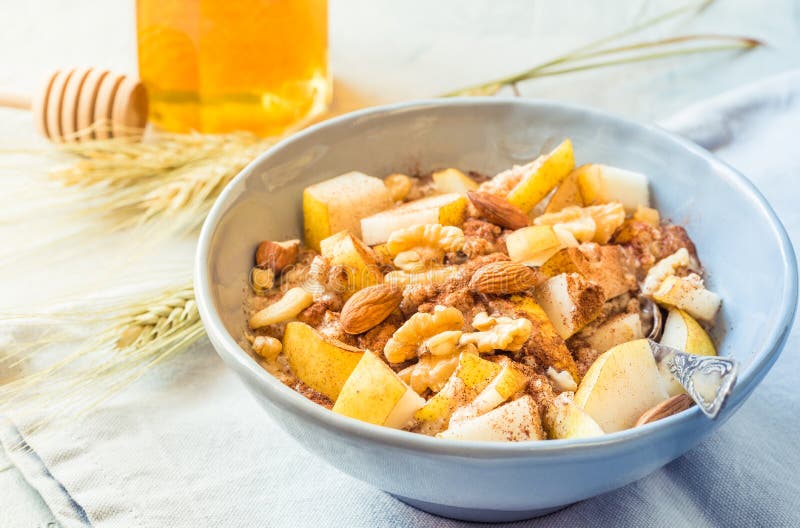 Oatmeal κύπελλων κουάκερ με το υγιές πρόγευμα φρούτων στον ηλιόλουστο πίνακα πρωινού στοκ εικόνα με δικαίωμα ελεύθερης χρήσης