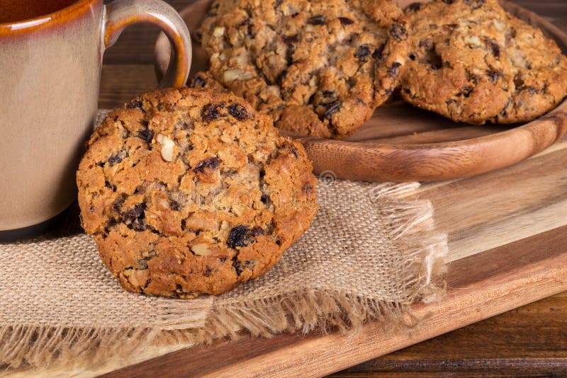 Oatmeal πεκάν σταφίδων μπισκότο ενάντια σε ένα φλυτζάνι καφέ στοκ φωτογραφία με δικαίωμα ελεύθερης χρήσης