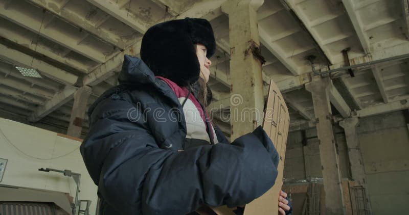 Obdachlose Kaukasier in schmutzigen Kleidern, die mit dem Hilfesystem stehen und um Hilfe bitten Hungriges gefrorenes Kind