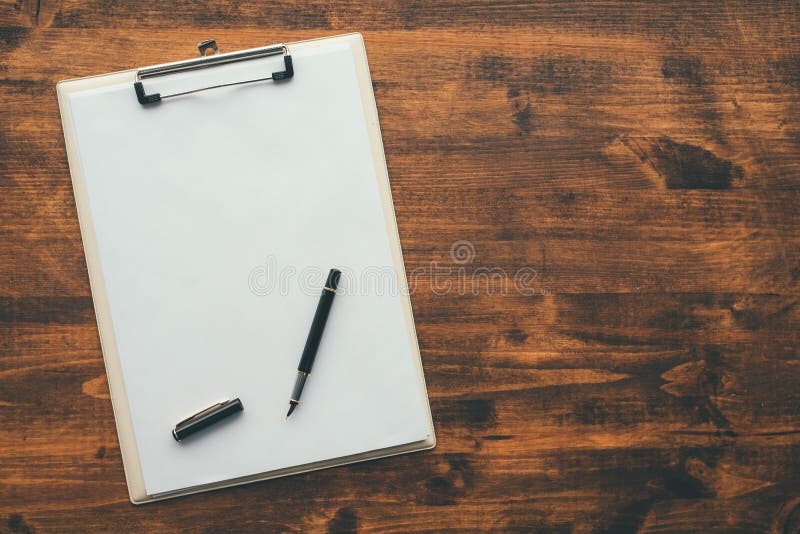 Obenliegende Ansicht des leeren Klemmbrettnotizblockpapiers mit Stift stockfotografie