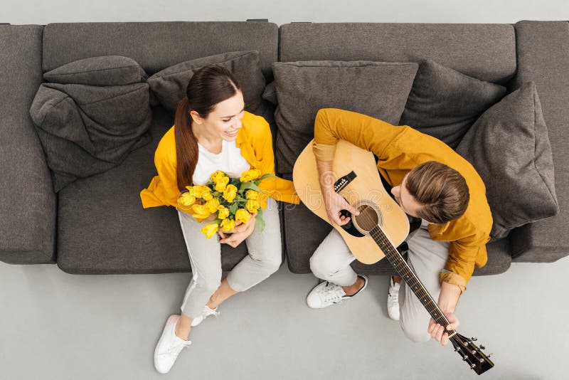 Obenliegende Ansicht des Mannes Gitarre zu seiner Freundin spielend stockfotografie
