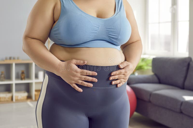 Overweight, Obese Woman in Sports Bra and Leggings Holding Her Hands on Her  Fat Belly Stock Photo - Image of excessive, sport: 278226994