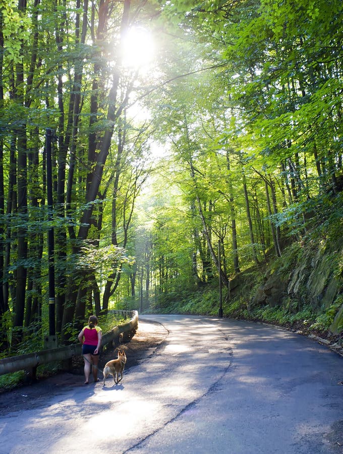 Obese young woman with dog on road