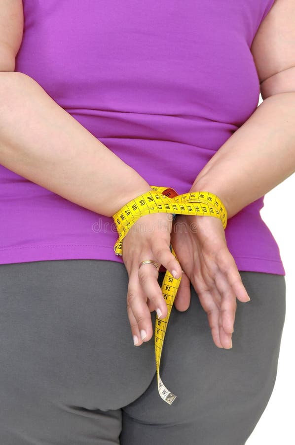Body part of a fat woman with hands tied up with measuring tape.