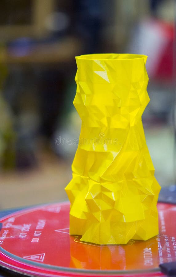 The object in the form of a yellow vase stands on the desktop 3d printer royalty free stock image