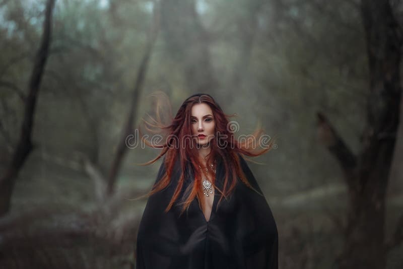 Obra de arte fantasia mulher gótica bruxa escura obcecada pelo mal. demônio de menina avermelhada no capuz preto. cabelo vermelho imagem de stock