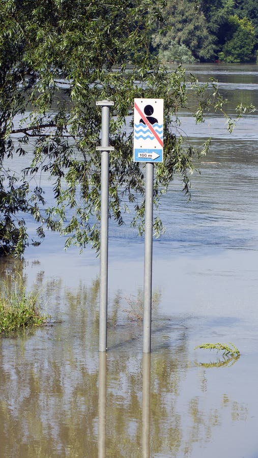Obraz uderzający przedstawiający zalany obszar z znakami drogowymi częściowo zanurzonymi w wodzie. obraz stock